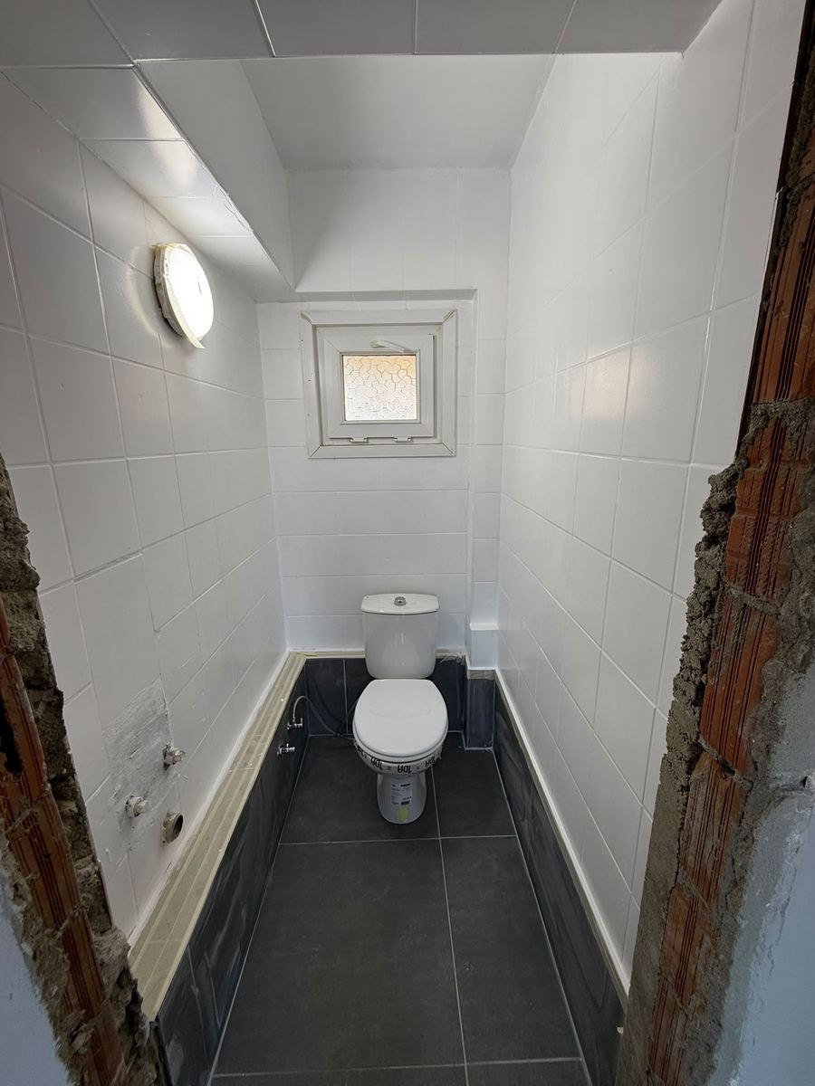 Beyaz seramikli WC, koyu renk süpürgelik