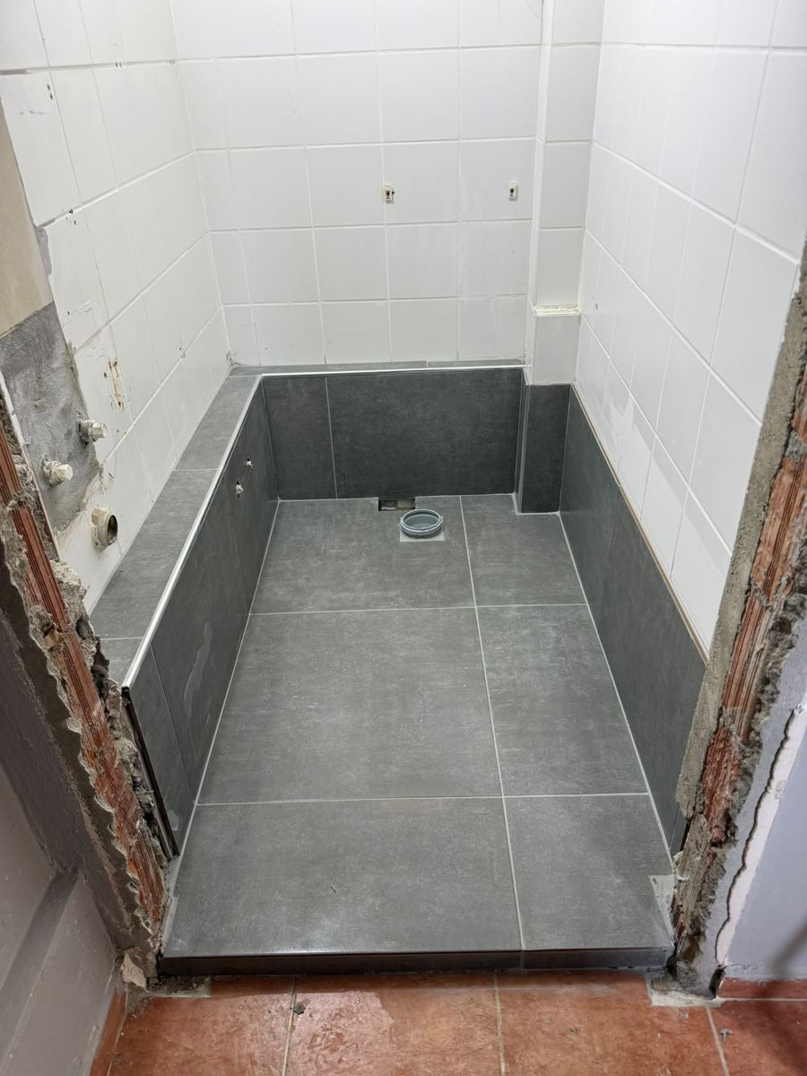 Banyo alanında koyu seramik zemin ve duvar kaplaması