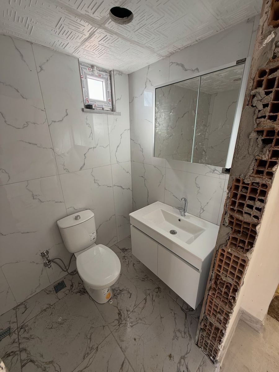 Beyaz mermer desenli banyo ve lavabo